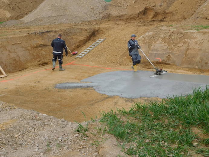 two men applying carefully a thin layer of concrete