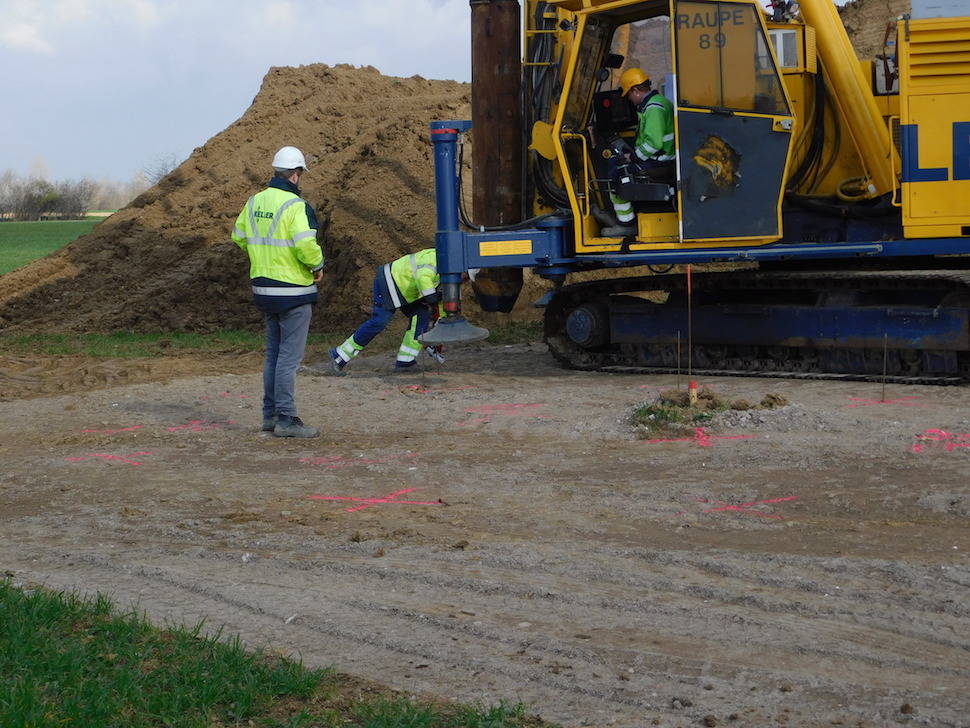 two workers in front of a depth vibrator checking the position for the next drilling